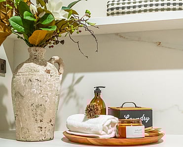 Close up image of laundry accessories and foliage in newly renovated heritage laundry room in deep sage & white. Renovated by local Te Awamutu residential builders, Whitechurch Construction.