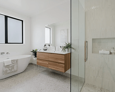 Image of modern neutral bathroom with timber cabinetry, pale grey tiling & glass door shower in Collinson Street, Pirongia new home, by Waikato residential builders Whitechurch Construction Limited.