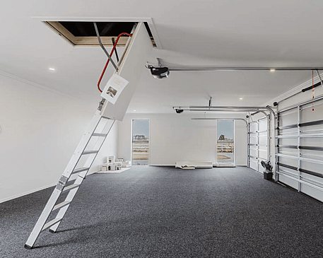 Image of fresh white garage with grey carpet and ceiling access in Collinson Street, Pirongia new home, by Waikato residential builders Whitechurch Construction Limited.
