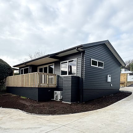 Image of a moody dark blue cladded small building with decking on Vercoe Road. Built by Ardent Building Developments, Hamilton. Waikato, New Zealand.