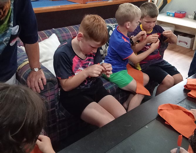 Children at the new Ingestre Street Rally hand stitching the hems for their sashes. Next time they will be eligible to get their members badges to stitch onto their sashes.