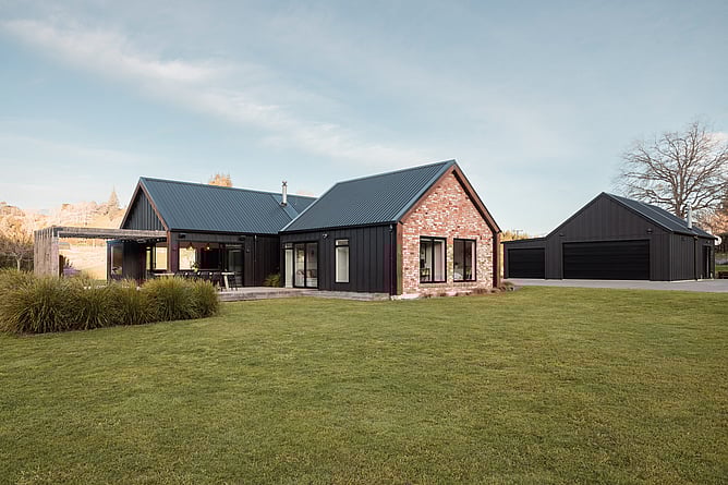 Black board and batten home with red brick