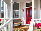 Front entrance way of Villa Rosa with bench on the deck