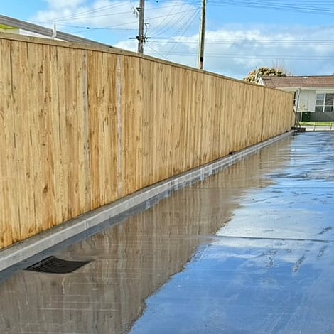 Image of a high timber fence along a a long concrete driveway. Built by Ardent Maintain, a division of Ardent Building Developments. Hamilton, Waikato, New Zealand.