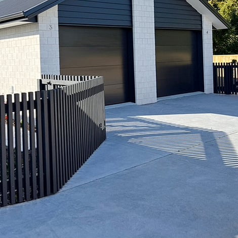 Image of black timber fencing surrounding a new home build property and new driveway. Built by Ardent Maintain, a division of Ardent Building Developments. Hamilton, Waikato, New Zealand.