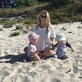 Photo of Jess on the beach with two young children