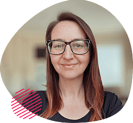 Smiling woman with glasses and long brown hair, wearing a black top, framed by an abstract beige shape with a pink striped accent