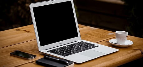 Laptop and coffee on a desk for finance reporting