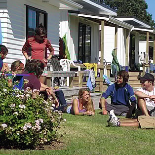 Students enjoying a sunny spot outside the cabins
