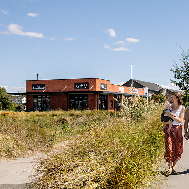 couple walking on pathway with Cafe building in the background