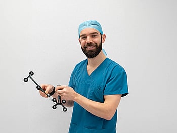X-ray illustration of a human pelvis and hip bones, showing detailed outlines of the skeletal structure, including the femur and pelvis, against a dark background.