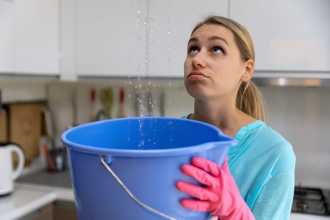 woman holding bucket for leaking roof
