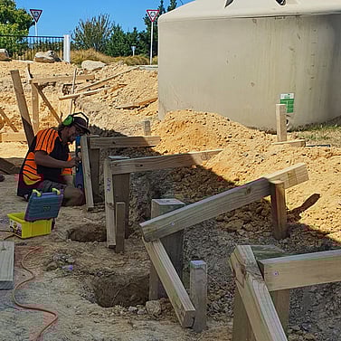 Building timber retaining wall foundation during excavation in Nelson