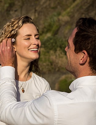 Couple share a sweet moment as man puts flower behind his wife's ear