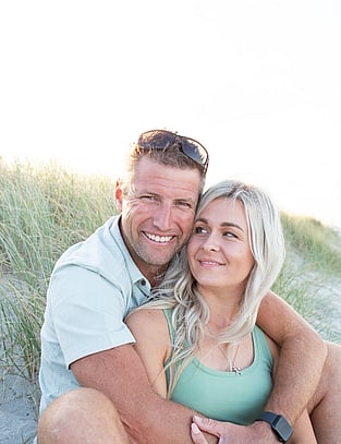 Couple in embrace smiling gently on the beach