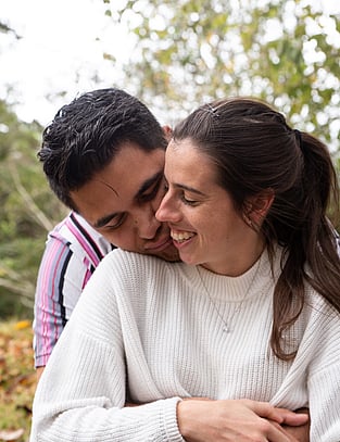 Couple share a sweet moment as man hugs his fiancee from behind