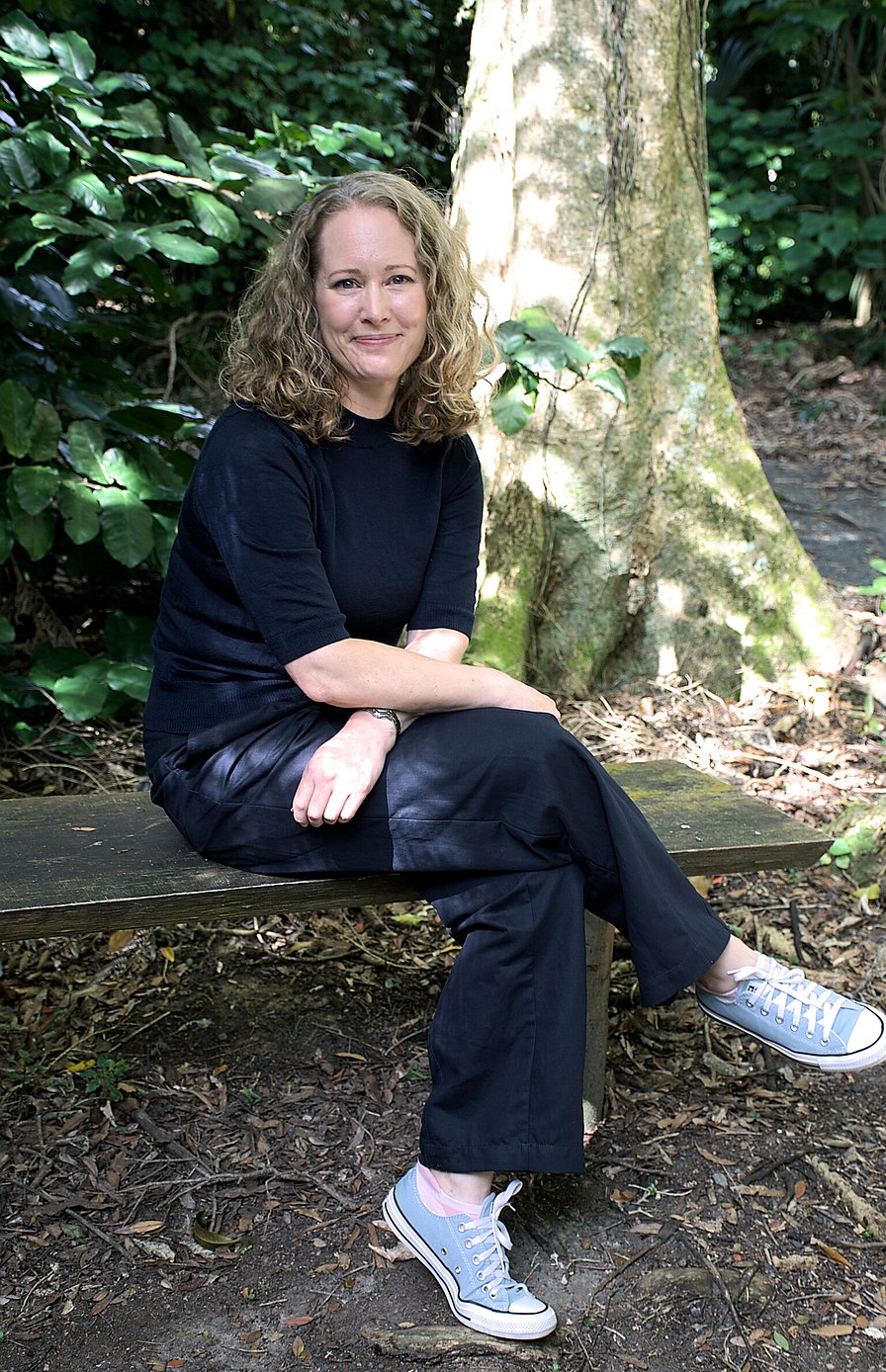 Woman sitting on a bench in a forest in Wellington New Zealand
