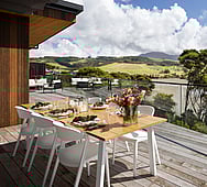 Master bedroom ensuite opening to private balcony &mdash; coastal home, Raglan estuary view