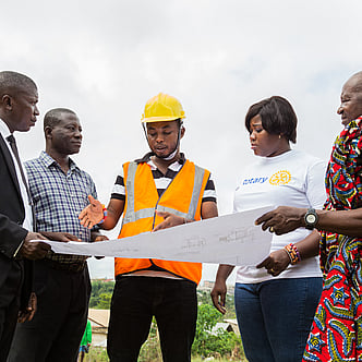 A group of people standing around a construction plan