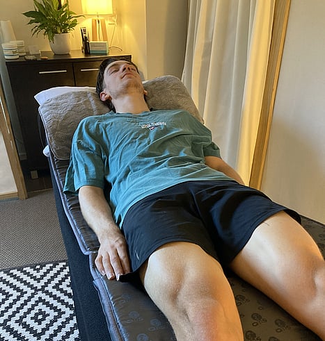 Picture of a young man lying on the pemf mat