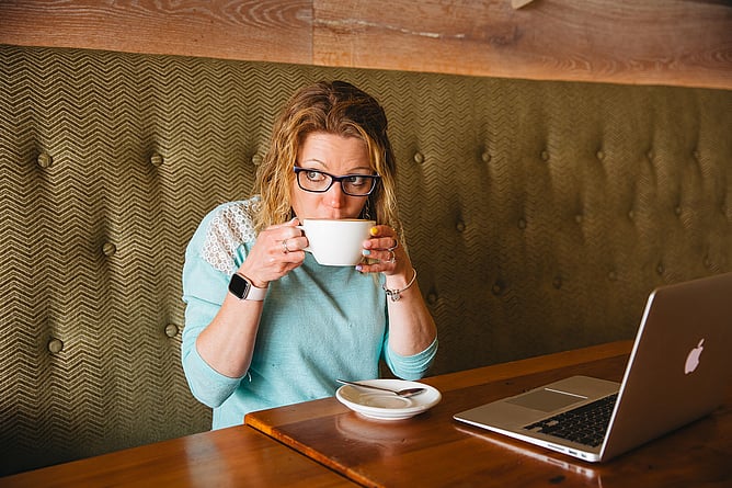 Strategic brand designer drinking coffee symbolising intentional wedding business branding versus rushed design