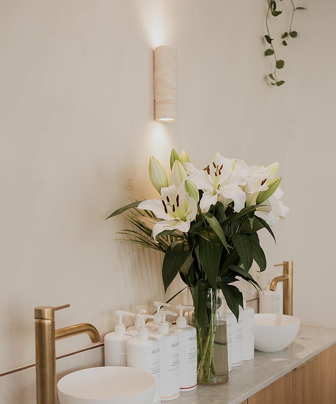 The Wild Daisy Hair back basin with Keune haircare range and a beautiful bunch of lilies in a vase.
