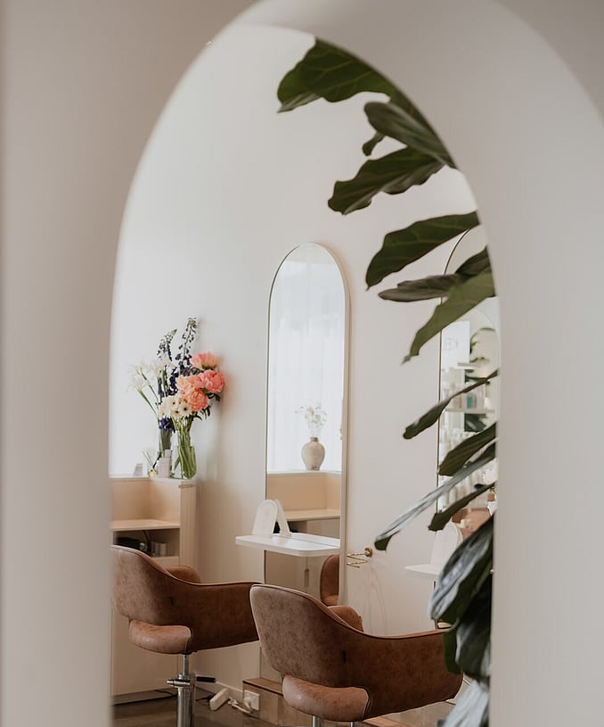 A view through a custom archway to the styling stations at Wild Daisy hair in Frankton.