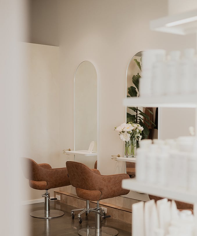 The cosy designer interior of Wild Daisy hair with rounded mirrors, and comfy brown chairs.
