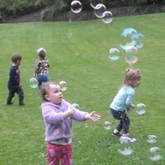 children having fun with bubbles at park
