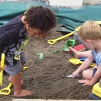 Boys digging in sandpit 