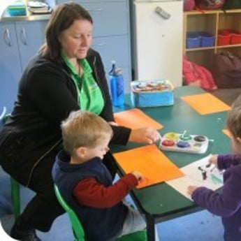 Educator and children painting