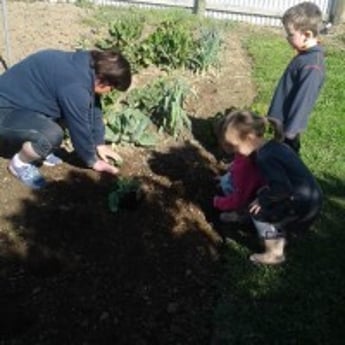 Kids and in-home educator gardening