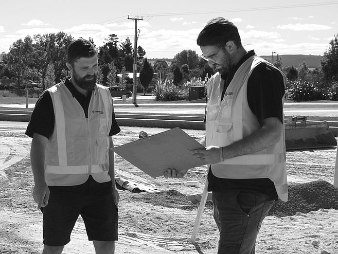 two male project managers looking at a clipboard