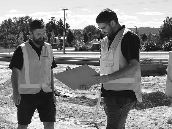 two male project managers looking at a clipboard