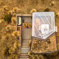 Aerial view of a SkyScape glass-roof cabin set into the Mackenzie landscape