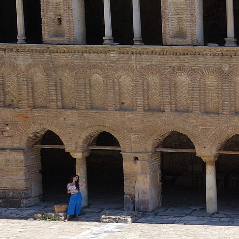 A lady poses for pictures in front of the Church of Hagia Sophia in Ohrid.