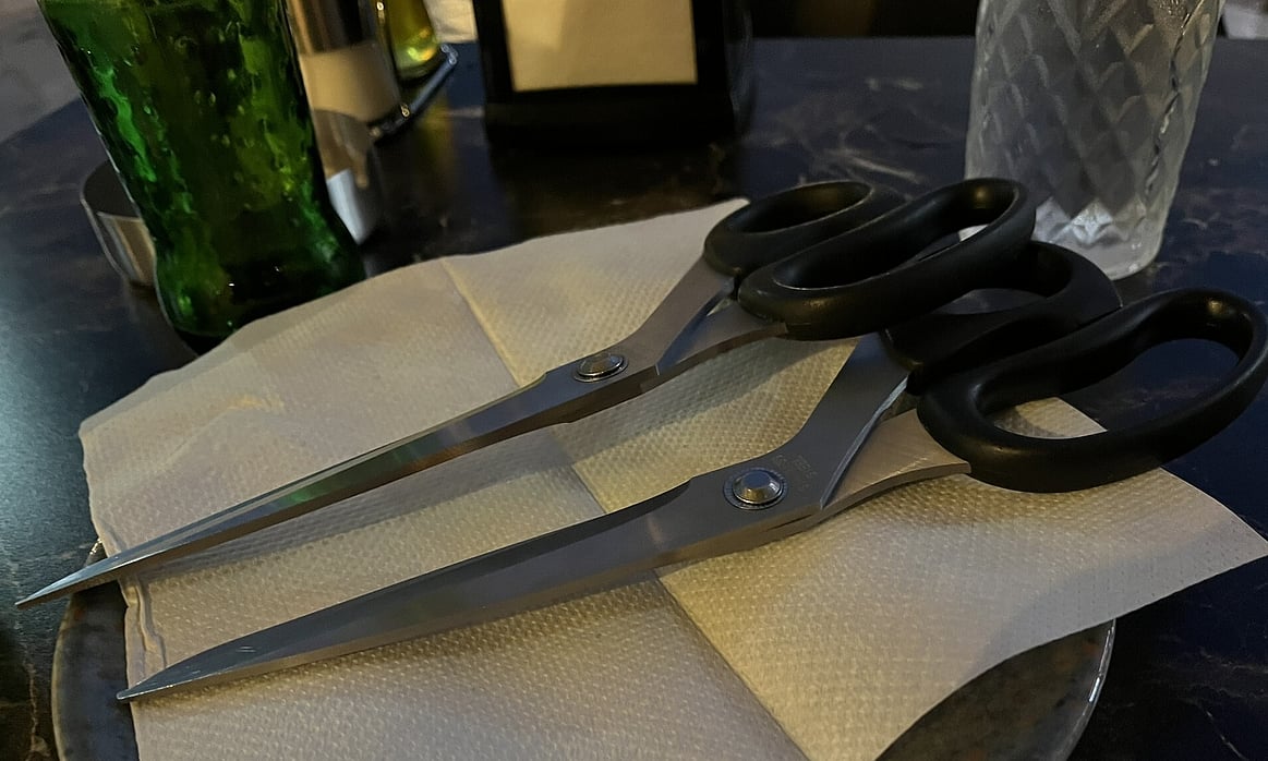 Two large pairs of scissors for cutting pizza at Da Lori restaurant in Ohrid, North Macedonia.