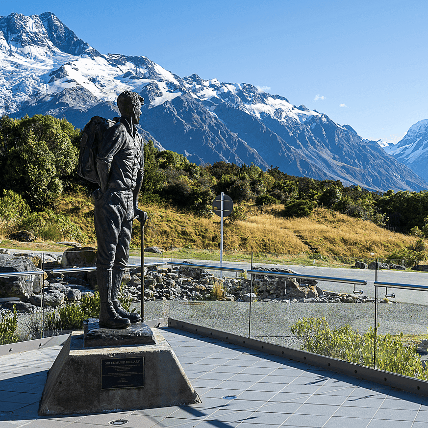 Statue of Sir Edmund Hillary with snow-covered mountains behind