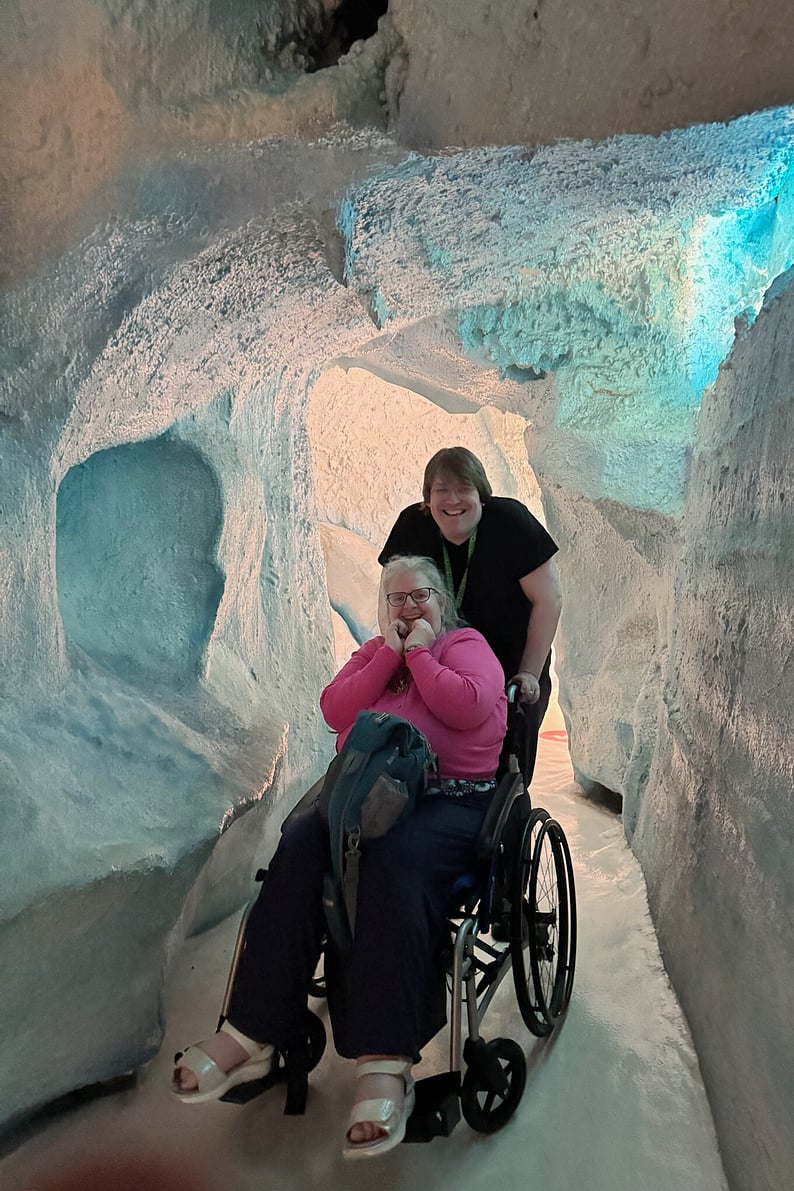 Traveller using manual wheelchair with guide in New Zealand nature setting, enjoying flexible support, in a glacier in the South Island of NZ