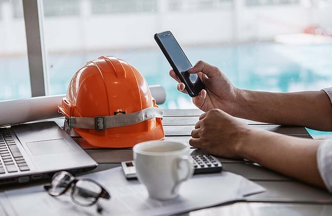 Trade business owner reviewing marketing costs and profit on laptop