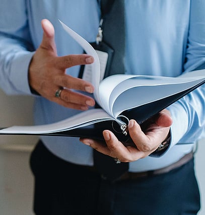 Man holding a binder and flipping through the pages