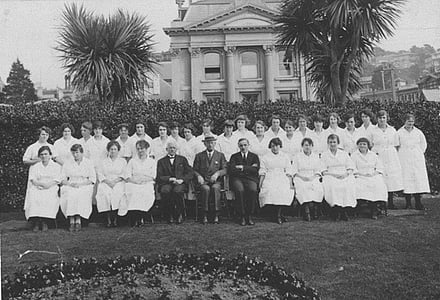 First draft of dental nurse students with Richmond Dunn (Director of the dental nurse training school), Colonel Thomas Hunter (Director of the Division of Dental Hygiene), and James Parr (Minister of Public Health), 1922. Early Period [of Dental School] [Archives Reference: ABKI 667 W4078 1/] Archives New Zealand, The Department of Internal Affairs Te Tari Taiwhenua.