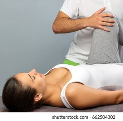 Picture of Osteopath working on a patient who's lying on the massage table
