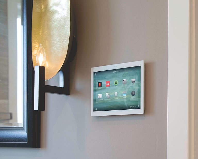 A wall mounted home control system panel by Control 4.