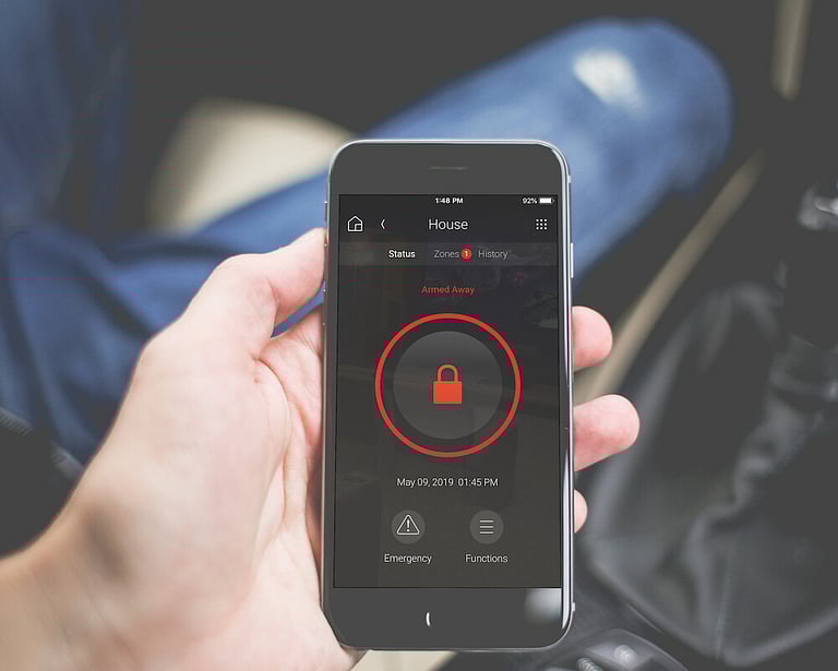 A phone with the home security application on the screen.