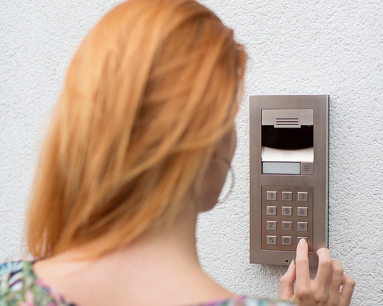 A person using a wall mounted access keypad.