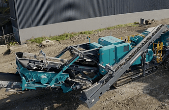 Aerial view of a Powerscreen Trakpactor 260SR rock crusher, crushing waste concrete for recycling into recycled crushed concrete aggregate