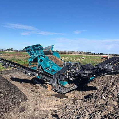 A powerscreen Warrior 1200 screening machine working on screening crushed rock
