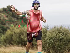 Trail runner, all smiles at blazing hills, on top of a hill with all the views . Head phones and a peace sign