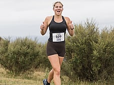 Woman Running. Happy strong, smiling. At blazing hills thumbs up.